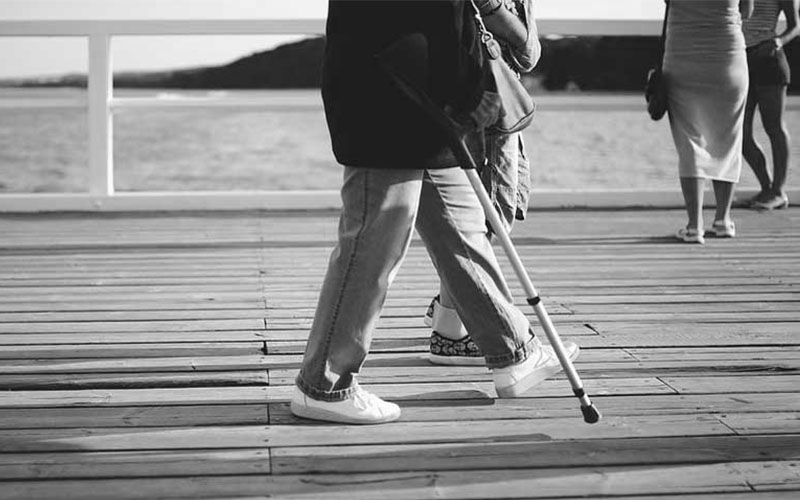Elderly person walking with cane