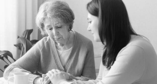 elderly woman being comforted by caregiver after abuse